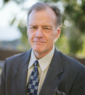Law professor Jack J. Coe Jr. posing for a professional headshot outdoors wearing a suit and tie.